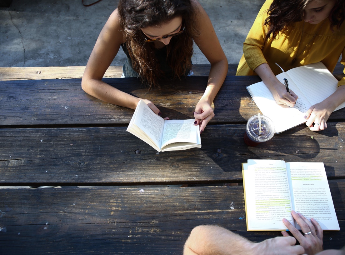 aerial view of a few students studying outdoors on a wooden table