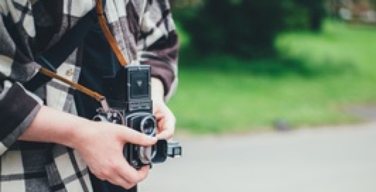 a student holding an old-fashioned camera